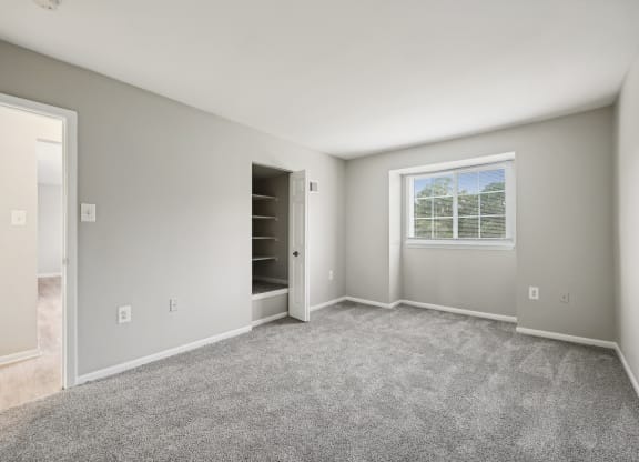 an empty room with carpet and a door to a closet at ReNew Odenton