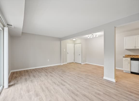 the living room and kitchen of an empty house with wood flooring at ReNew Odenton