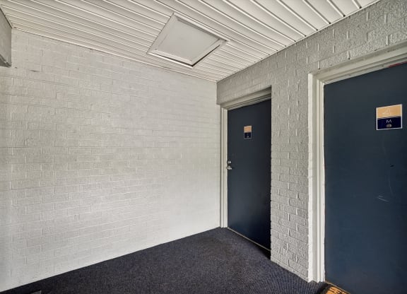 a hallway with two blue doors and a white brick wall at ReNew Odenton