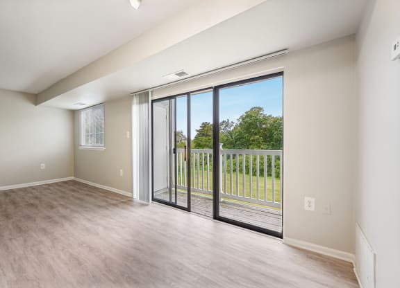 an empty living room with sliding glass doors to a balcony at ReNew Odenton