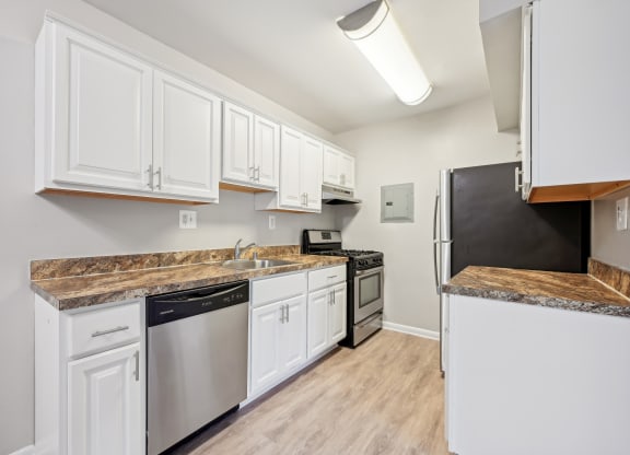 a renovated kitchen with white cabinets and stainless steel appliances at ReNew Odenton