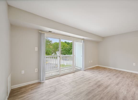 an empty living room with sliding glass doors to a balcony at ReNew Odenton