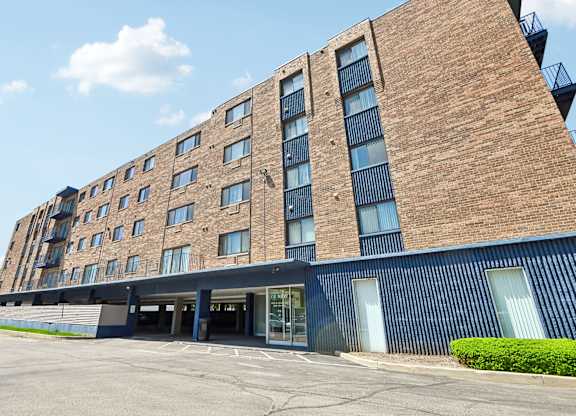 A large brick building with a parking lot in front.