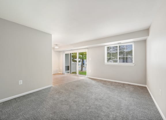 an empty living room with a window and a door to a yard at ReNew Odenton