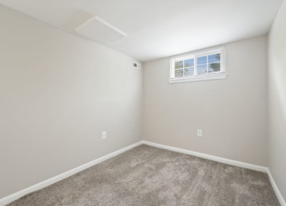 an empty room with carpet and a window at ReNew Odenton