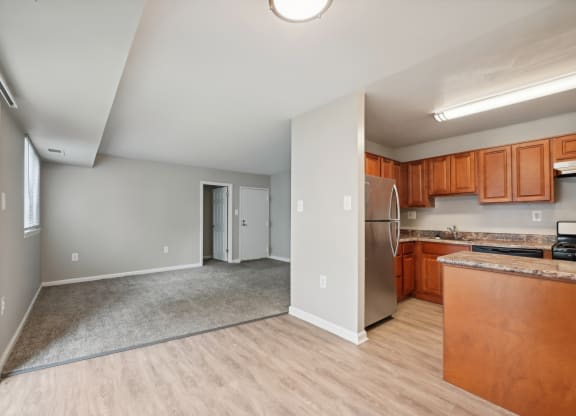 a kitchen and living room with wood flooring and a stainless steel refrigerator at ReNew Odenton