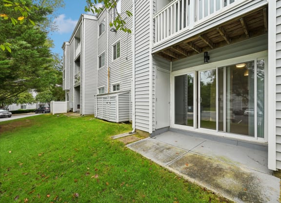 View from outside into an apartment complex with patio and sliding doors at ReNew Odenton