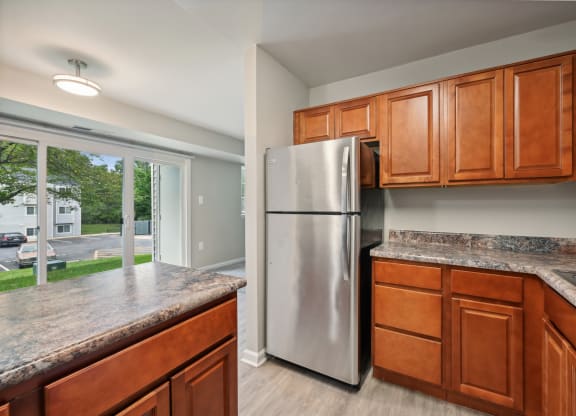 a kitchen with wooden cabinets and a stainless steel refrigerator at ReNew Odenton
