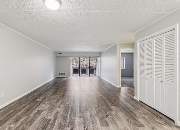 A room with wooden flooring and white walls.