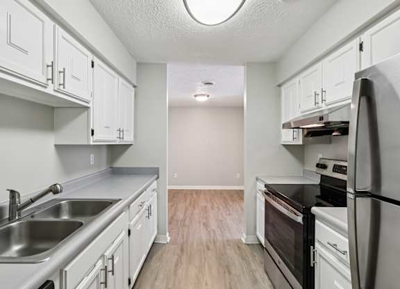 A kitchen with white cabinets and stainless steel appliances.
