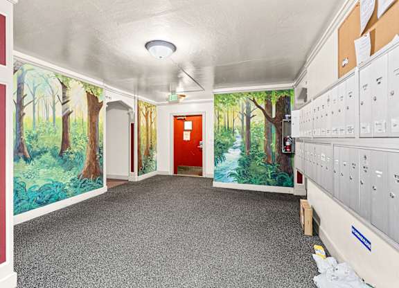 A hallway with a mural of a forest scene on the walls.