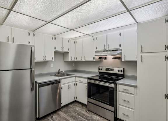 A kitchen with white cabinets and stainless steel appliances.