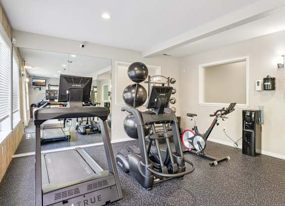 Fitness center with a treadmill, stationary bike, and other exercise equipment.