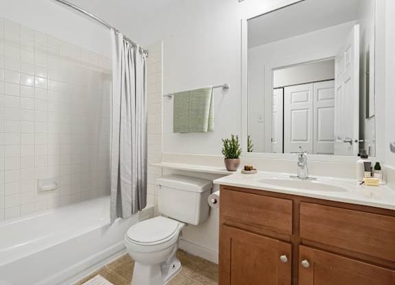 A white toilet sits next to a white bathtub in a bathroom.