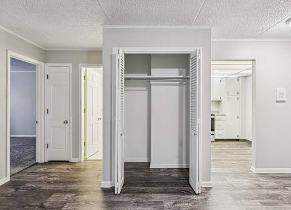 A white door is open in a room with a carpeted floor.