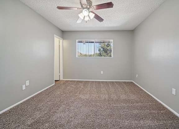 A room with a ceiling fan and carpeted floor.