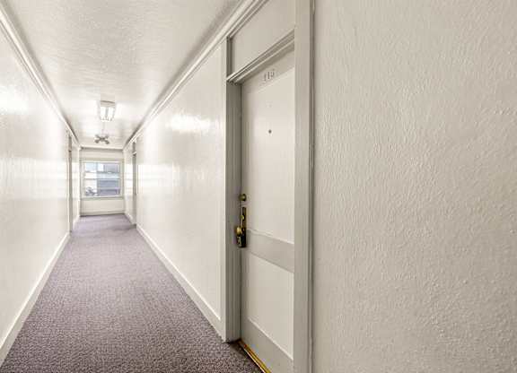 A long hallway with a door on the right.