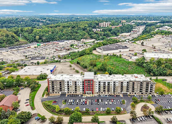 An aerial view of a parking lot with a large building in the background.