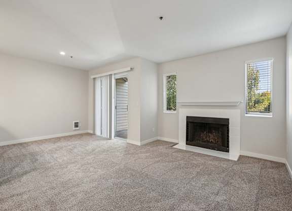 A living room with a fireplace and a sliding door.