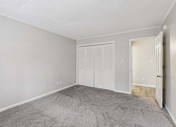 A room with grey carpet and white walls.