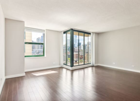 an empty living room with hardwood floors and a large window