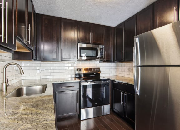 a kitchen with stainless steel appliances and dark wood cabinets
