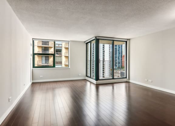 an empty living room with wood flooring and a large window