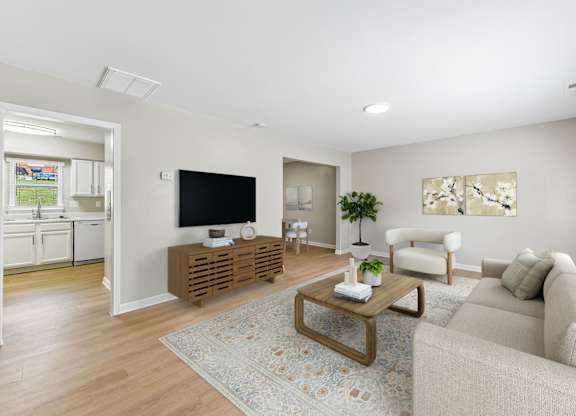 A living room with a couch, a coffee table, and a television.