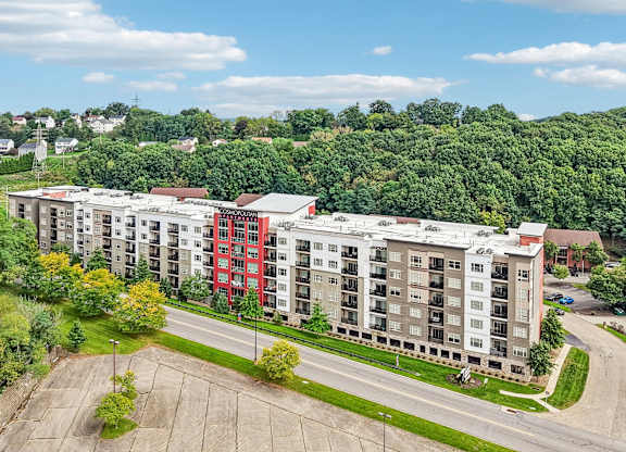 A large apartment complex with a parking lot in front.