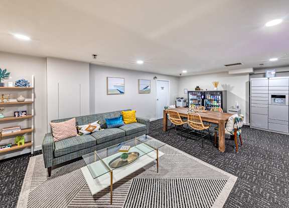 Room with a grey couch, a glass coffee table, and a wooden dining table with chairs. at Oak Park City, Oak Park, IL