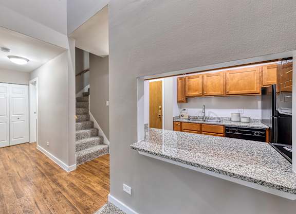 Room with a glimpse into the kitchen and carpeted staircase at Oak Park City, Oak Park, IL 60301