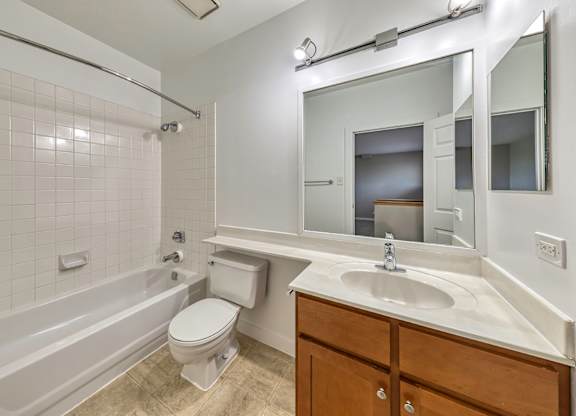 A white bathroom with a toilet, sink, and bathtub. at Oak Park City, Oak Park, 60301