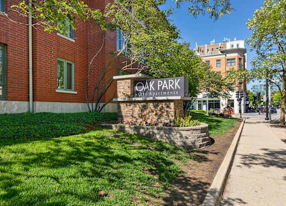 A sign for Oak Park Apartments is in front of a brick building. at Oak Park City, Oak Park Illinois
