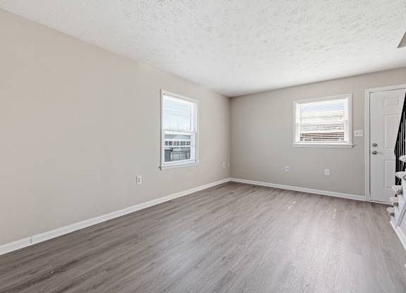 A room with light brown flooring and white walls.