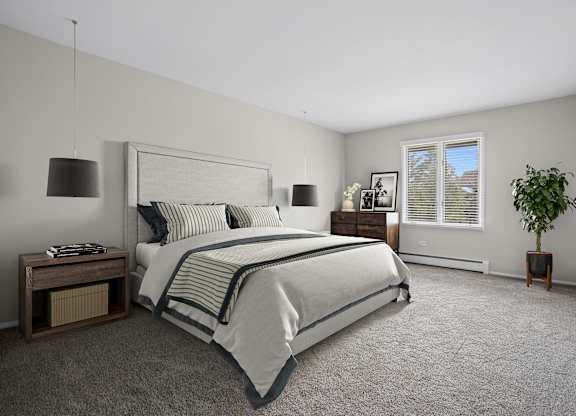 A bedroom with a large bed and a potted plant.