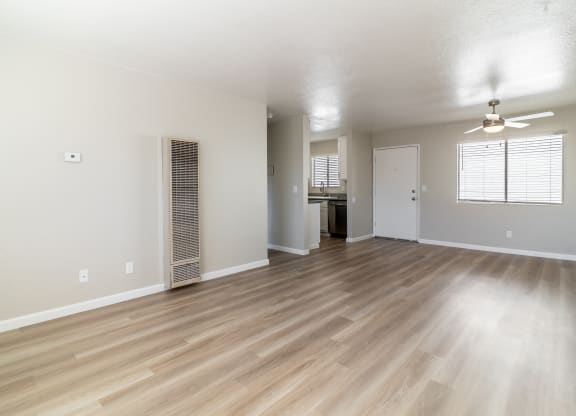 an empty living room with hardwood flooring and a kitchen at Alturas Paso Robles Apartment Homes, California