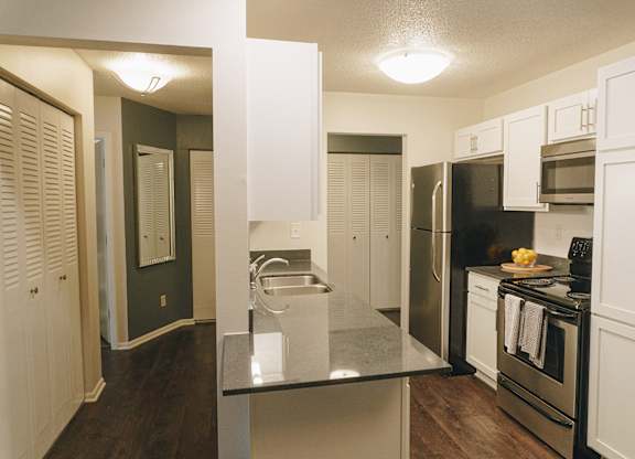 A kitchen with white cabinets and a black fridge at Astor Place of Edina Apartments , Edina, MN, 55435