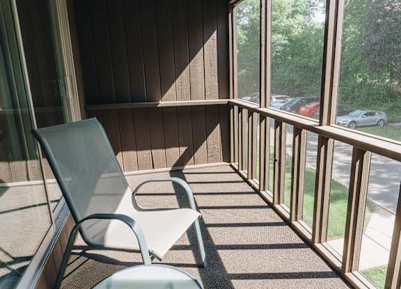 A chair and table are on a sunny balcony at Astor Place of Edina Apartments , Edina, 55435