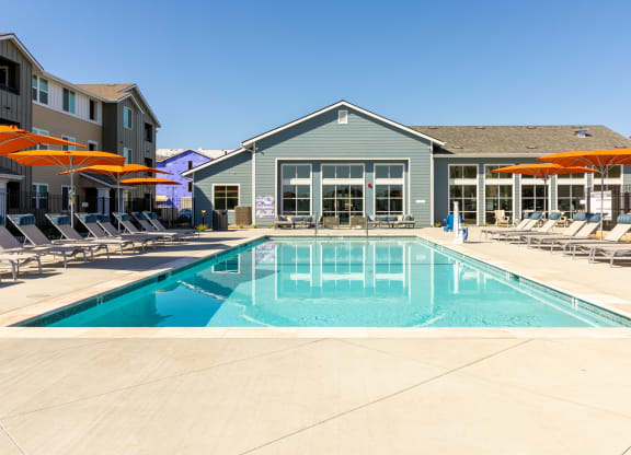 a swimming pool with chairs and umbrellas next to a building at Arrive Paso Robles, California, 93446