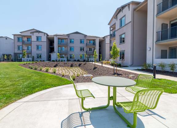 A green chair and table are in the foreground of a residential area.