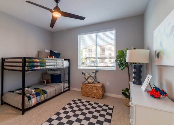 A room with a bunk bed and a black and white checkered rug.