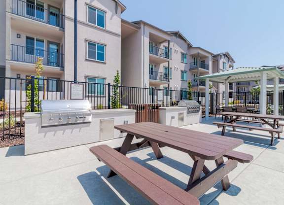 A picnic table is in the foreground of a courtyard with apartment buildings in the background.