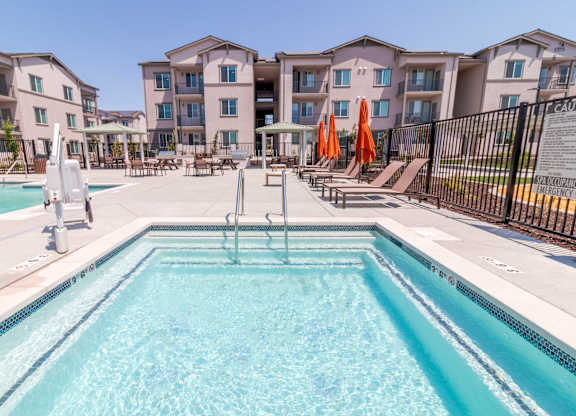 A swimming pool in front of apartment buildings.