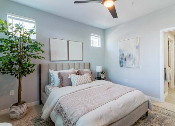 A bedroom with a large bed and a ceiling fan.