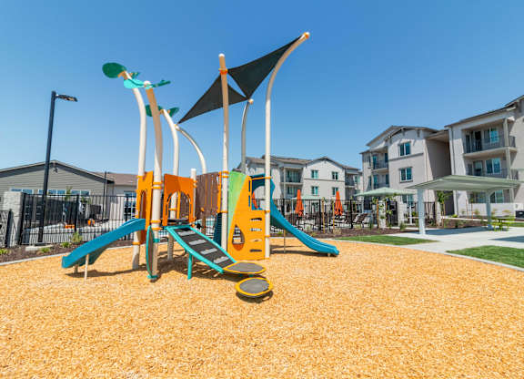 Kids playground with slides and apartment buildings in the background