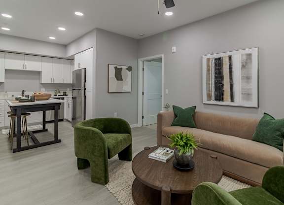 A modern living room with a green armchair and a brown sofa.