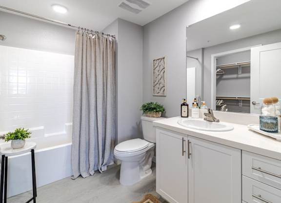 A white bathroom with a toilet, sink, and shower.