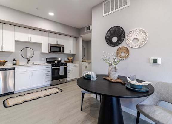 A modern kitchen with a dining table and chairs.