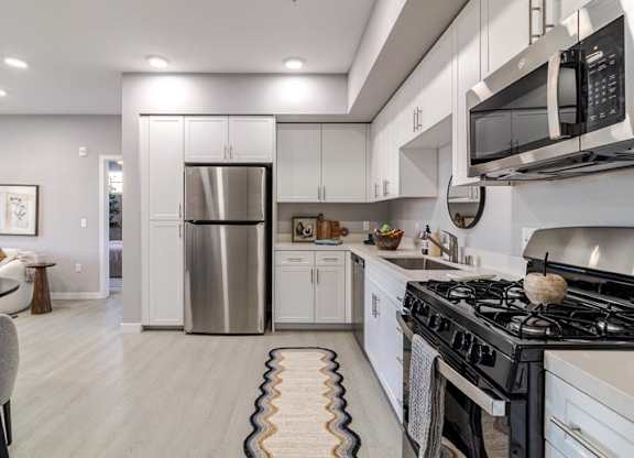 A modern kitchen with a stainless steel refrigerator and a black stove top.