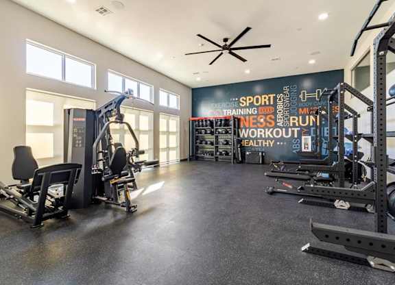A gym with a variety of equipment and a sign that reads 